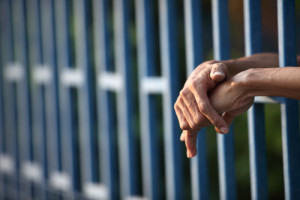 hands reaching out from a jail cell